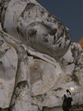 A Woman Stops to Reflect at a Statue of a Reclining Buddha