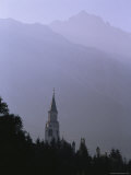 A Church Spire Silhouetted against a Mountain Range