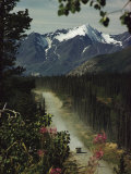 A Camper Rolls Down a Dirt Road Below High Mountains in Alaska