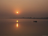 Fishermen in a Boat Greet the Sunrise on a Foggy Morning