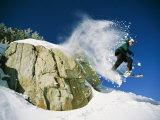 Snowboarder Jumping off a Big Rock