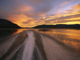 A Jet Boat Leaves a Wake in the Mackenzie River at Sunset