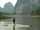 A Water Buffalo Pulls a Farmer on Bamboo Raft Across Mingjiang River