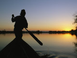 A Silhouetted Burmese Man in a Canoe at Sunset