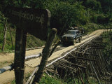 A Truck Carefully Making its Way Across a Rickety-Looking Bridge