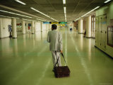 An Exhausted Traveler Drags His Bag Through Bangkoks Airport