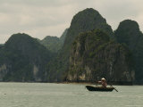 Woman in a Conical Hat Rows a Traditional Fishing Boat in Halong Bay