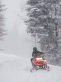 A Woman Speeds Along on a Snowmobile in a Blizzard