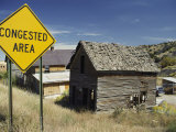 A Yellow Street Sign Reading Congested Area Next to a Run-Down Barn