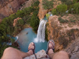 A Look Over a Cliff at a Waterfall Far Below Between Two Feet