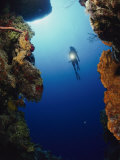 A Diver Swims Between Two Underwater Cliffs