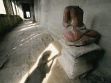 The Headless Statue of a Seated Buddha Sits in a Hallway in a Buddhist Temple