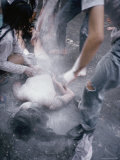 Celebrants at the Songkran Water Festival Douse a Person Lying in the Street