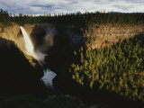 A Waterfall Spills into a Deep Canyon Surrounded by Forest