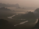 A Winding River Passes Among Jagged Mountains Rimmed with Fog