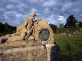 A Statue of a Soldier Kneeling against a Wall with His Rifle