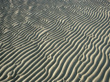 Water Forms Ripples in the Sand on a Beach