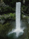 A Waterfall Pours into a Small Pool from High Above