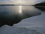 Sunlight Reflects off the River Lined with Ice and Snow