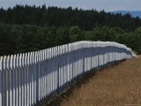 A White Picket Fence Recedes Down a Field