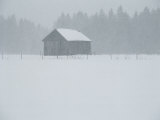 A Barn Behind a Fence in the Snow