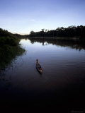 Indian Crewmen Paddle Upriver in a Dugout Canoe at Twilight to Fish
