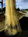 A Weighted Fishnet Hung Next to a Primitive Canoe on the Remote River