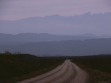 Twilight View of Road Leading to Fog-Shrouded Mountains