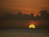 A Silhouette of a Sailboat against the Setting Sun