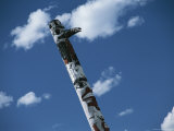 Indian Totem Pole against Blue Sky with Puffy White Clouds
