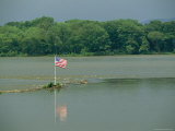 An American Flag Marks a Rock Outcrop Near a Ferry Crossing