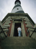 A Woman Enters the Towering Cape Hatteras Lighthouse