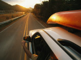 Car with a Kayak on Top Speeds down a Two-Lane Highway