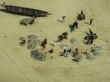 Fishermen and Canoe on Beach Loading Their Catch onto Wagons