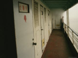 Passenger Stands Against a Railing on a Boat Deck near Bathrooms