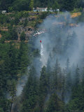 A Firefighting Helicopter Douses a Forest Fire Threatening Homes