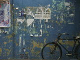 A Bicycle is Parked against a Blue Wall
