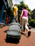 A Couple Walking with Luggage Through Chinatown