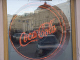 A Neon Coca Cola Sign is Displayed in a Window