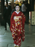 Kimono-Clad Geisha Walks Past Shops Among Other Pedestrians