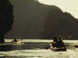 Tourists Kayak Alongside Karst Limestone Formations of Halong Bay