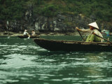 A Woman in a Traditional Boat Rows from Floating Village to Village  Halong Bay