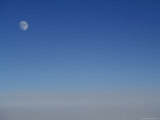 The Moon Above a Layer of Clouds Seen from an Airplane Above Alaska