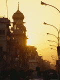 Commuters in Cars and Rickshaws Pass by a Mosque at Sunset after Work