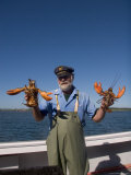 A Man Holds up Two Big Lobsters