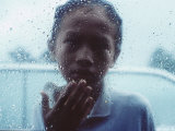Indonesian Muslim Boy Begs for Money Through a Car Window in Rain