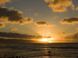 A Surfer Wades into the Water at Rocky Point at Sunset