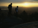 Hikers Survey the Landscape from Atop a Mountain at Twilight
