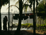 A New Mother in a Sari Walks with Her Baby Along the Shore of a Pond