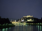 The City is Illuminated at Night Casting a Soft Glow onto the River  Salzburg  Austria